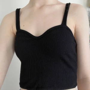 Svart linne - Ett ribbat svart linne med ”sweatheart neckline”. Linnet är i dubbelt lager tyg och av lite tjockare kvalitet. Nästan helt oanvänt.