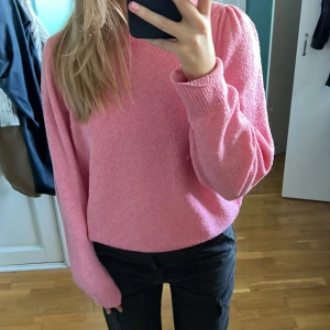 Stickad rosa tröja - Stockad tröja i en jättefin rosa färg. Den har en snygg detalj på axlarna(bild 2). Det går att dra bak den så synns det inte.