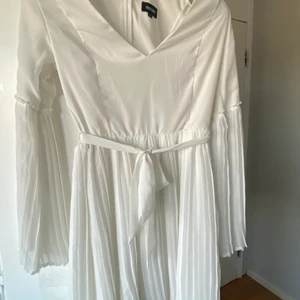 Vit sommarklänning från bubbleroom  - Jättefin till middagar, fester, skolavslutning eller student!💕 jättehärligt material💕 i storlek 34! Kontakta för fler bilder ☺️ vit med utsvänga armar i räfflat mönster. Knytbar midja och perfekt längd💕