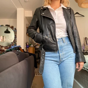 Svart skinnjacka - Svart skinnjacka från Crocker. Välanvänd men fortfarande snygg! Dragkedjor i ärmarna för lös eller tight passform. Många fickor. Snygg både öppen och stängd!
