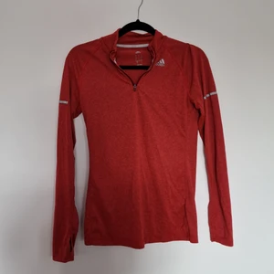 Träningströja adidas - Långärmad röd träningströja från adidas. Hål längst ner på ärmarna för tummarna. Använd ett fåtal gånger. Storlek S   Katt finns i hemmet
