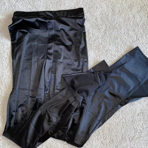 Byxor med slits S NLY - Ett par byxor från NLY One i sammetsliknande material. Svarta och glansiga, ser glittriga ut på de två första bilderna men är inte det. Båda byxbenen har slits på sidan som går över skon/foten. De är långa (jag är 174cm) och sitter väldigt bra! Aldrig använda så är i nyskick❤️‍🔥