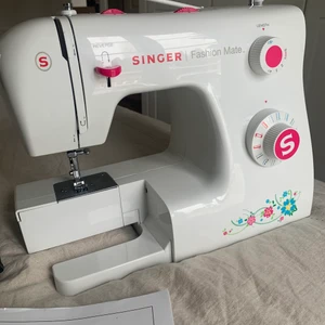 Symaskin💖 - Nästan helt oanvänd och i bra skick! Fick i julklapp förra året men inte intresserad längre. Fungerar bra! Det ska finnas en låda framför nålen med tråd och sånt men den är tyvär borta. Men symaskinen i själva verket funkar utmärkt.❤️ Man får tillbehören med i priset!Om man vill har jag ett typ kvar som jag köpt i lila färg, kontakta mig om ni vill ha bild på det också men då blir det 50kr extra! Vanligt pris= 2000