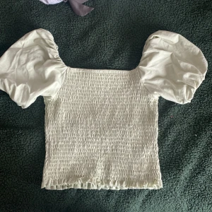 Tröja  - En tröja från Ginatrico som köptes för 3-4 år sedan som jag andvänt 1 gång. Säljs pågrund av att den aldrig andvänds. Gullig att ha på sommaren med en fin grön färg och gulliga puff armar! Org pris 250kr