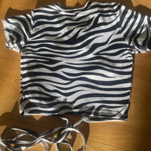 T shirt med öppen rygg - Säljer denna snygga t shirt för att jag inte använder den längre, den är i väldigt bra skick. Den är i storlek xxs men är väldigt stretchig. Frakten ingår inte i priset