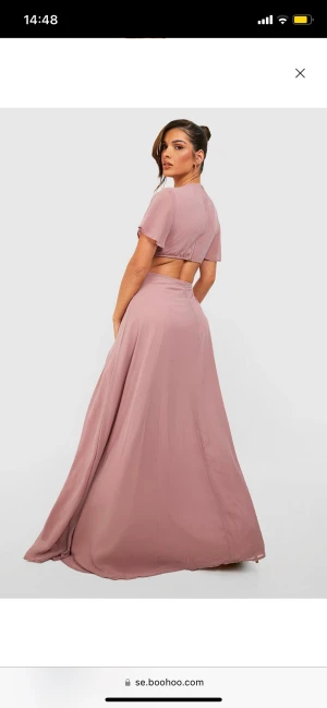 Rosa Chiffon klänning med öppen baksida - Chiffongtyget är lätt och luftigt, vilket gör att klänningen faller mjukt och smickrande över kroppen.Klänningen är elegant och sofistikerad, men samtidigt trendig. Klänningen har endast använts en gång och är inte till nytta längre därav säljer jag den.