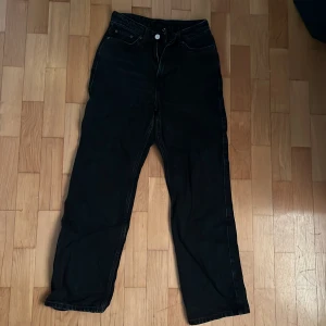 Svarta jeans från Weekday - Säljer mina svarta Weekday jeans i modellen Row. Väldigt fina och sparsamt använda. Tyvärr en liten defekt framtill vid gylfen.  Högmidjade och raka i benen.   Har kanin hemma.