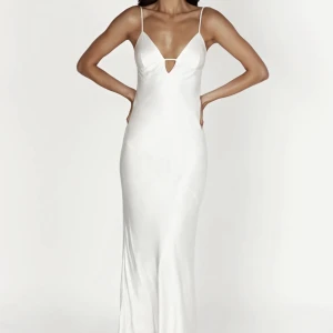 Balklänning med öppen rygg  - Vit siden balklänning med öppen rygg och knytning i bak. Från Meshki aldrig använd (nyskick). Storlek S, jag är 170 cm och den passar mig perfekt i längden med klackar på. Nypris 1000kr men säljer för 600kr.