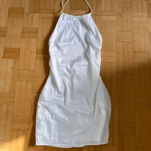 Vit klänning - Vit klänning från Nelly. Använd på studenten. Se sista bilden för hur den sitter på mig 😅 Strl 34.