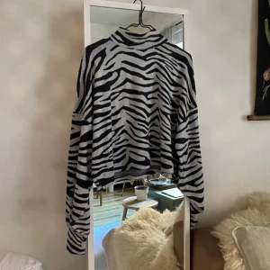 Polotröja strl M - Tiger-mönstrad polotröja med coppad längd och ballong-ärmar med muddar. I storlek M från BikBok. 