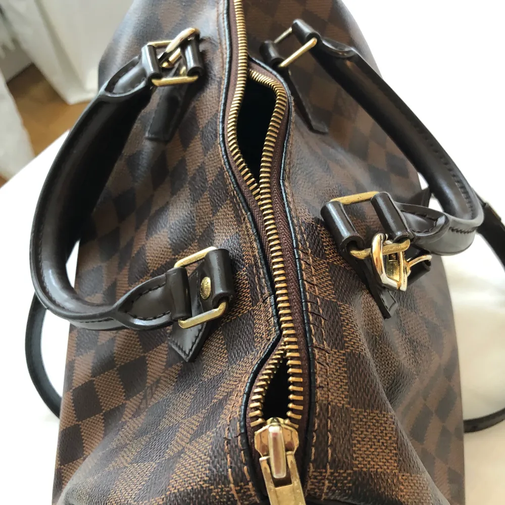 it is an old Louis vuitton damier speedy 30 bag it is damaged at the 4 corners under the I am selling it without a shoulder strap because I recently bought it separately. Väskor.