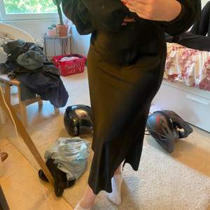 Svart siden kjol med slits i strl M från bikbok! Säljer för 100kr