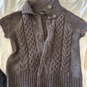Stickad tröja - Stickad kortärmad tröja med supersöta knappar! Passar superbra nu till våren Storlek XL men är liten i storlek så jag skulle säga att tröjan mer är en M/S