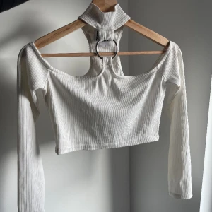 Vit crop top från The Ragged Priest  - Off-shoulder / halterneck topp. Finns en sminkfläck på insidan av kragen, annars i bra skick! 