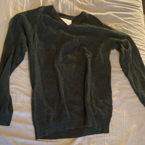 Mörkgrön stickad tröja  - En fin stickad tröja i mörkgrön färg. Lite nopprig men det går att fixa. 
