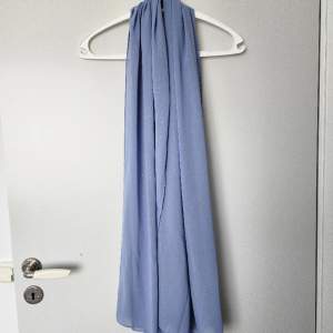 Ljusblå scarf med lite glitter på. Använd 1 eller 2 gånger. 178 x 71 cm