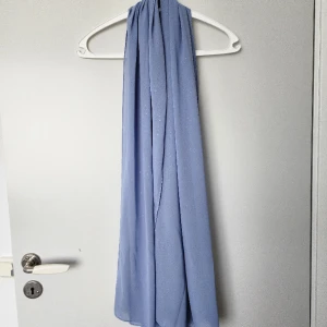 Ljusblå scarf  - Ljusblå scarf med lite glitter på. Använd 1 eller 2 gånger. 178 x 71 cm