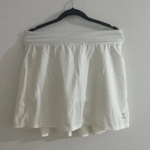 Vit padel/tennis kjol - Säljer denna helt nya/oanvända tenniskjolen som man även kan ha på gymmet! Dem har inbyggda shorts så inget kommer synas igenom, storlek 158-164, passar mig som har strl xs. 