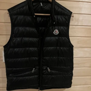 Moncler gui väst - Säljer nu denna svarta moncler gui väst storlek 1, den är i mycket bra skick och självklart är den äkta. Vänsten är ifrån Ssense.