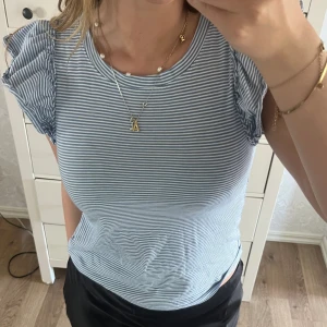 Jättesöt randig topp med volang  - Jag säljer en jättefin blåvit randig topp med volanger vid armarna. Toppen är ifrån kappahls barnavdelning och är slutsåld. Toppen är i ett jättefint skick och sparsamt använd. Storleksmässigt skulle jag säga att toppen är i S💙☀️🤩