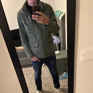 J Lindeberg Field jacka - Säljer en riktigt fet Field jacka då den inte kommer till användning på sistone - riktigt fint skick - den ser lite grå ut på bilderna men den är olivgrön - modellen på bilden är 190 - priset kan diskuteras vid snabb affär - hör av dig vid frågor!