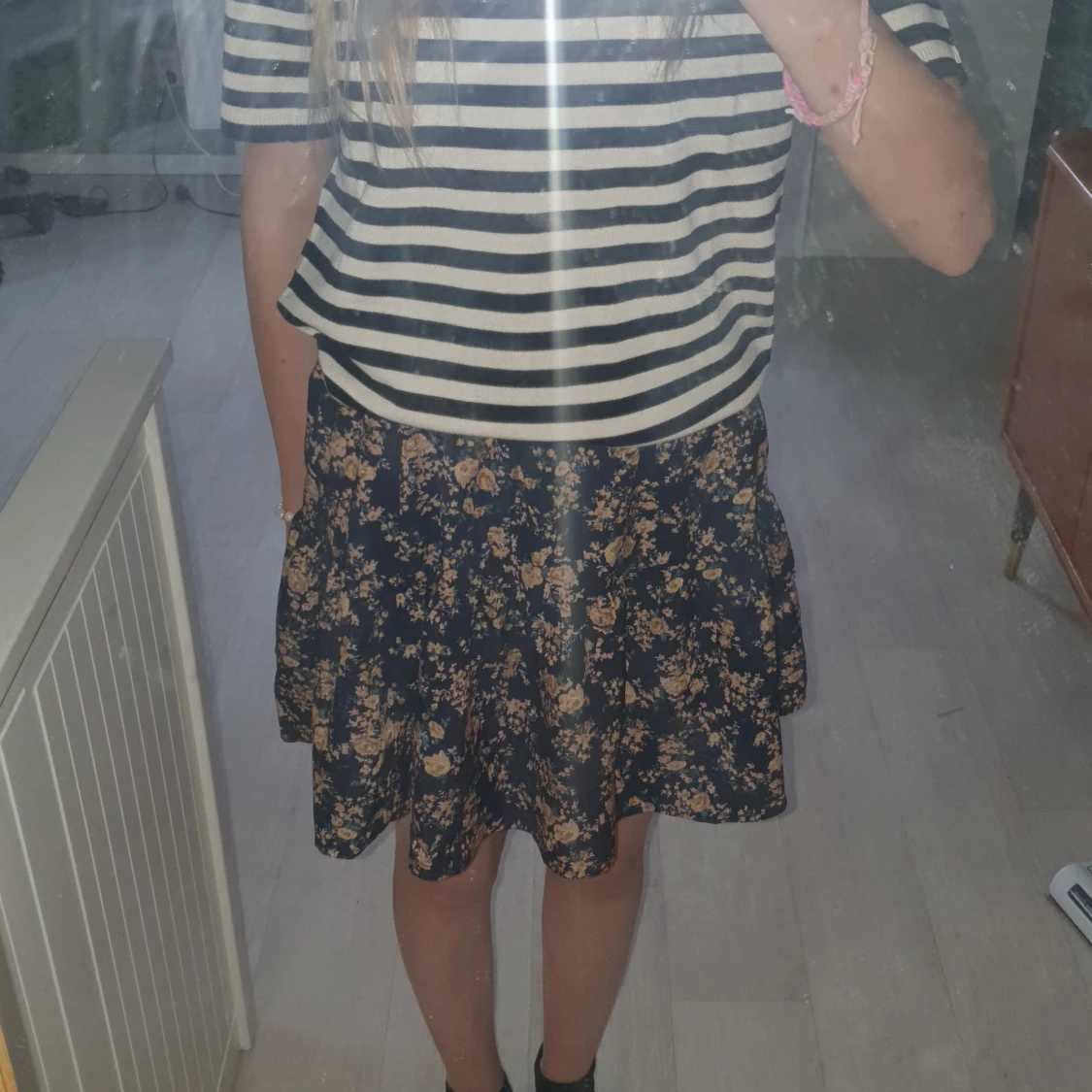 En svart kjol med rosa/bruna blommor - 90