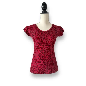 Top med rött leopardmönster - Supersöt top med liten puffärm.  Märkt som M men liten i storlek! Uppskattar den som en S. Mått rätt över: Under ärmarna 41cm, Längd 55cm