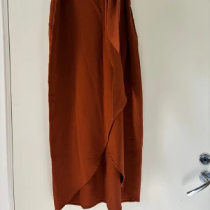 Kjol - Vinröd kjol, Som går att knyta vid magen och öppen vid benet 