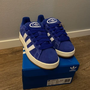 Adidas campus 00 - Adidas campus 00 blåa med både vita och blåa snören. Aldrig använda, storlek 39 1/3