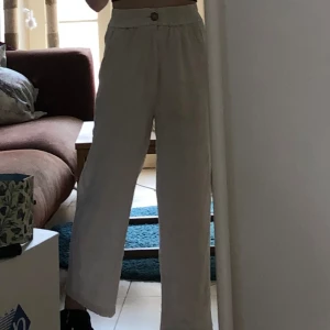 Vita/ljust beiga byxor i linneblandning - Vita/ljust beiga byxor i linneblandning från stradivarius. Väl använda men i gott skick. Har en liten fläck på baksidan men borde gå att fläckbehandla, annars inte särskilt synlig. Kort längd, passar bra för dig runt 160cm. Lätta att stryka.