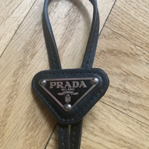 Prada Bolo tie - Prada bolo tie, använd få gånger så väldigt bra kvalite! Kommer med lådan
