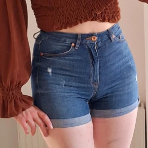 Högmidjade blå jeansshorts, shorts med hög midja strl XS/34 - Högmidjade blå jeansshorts, shorts med hög midja strl XS/34. Fint skick, knappt använda. Djurfritt och rökfritt hem. Missa inte mina andra annonser ❤️