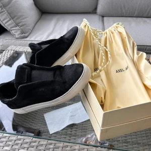 Axel Arigato laceless skor - Säljer dessa då de inte kommer till använd längre, de är storlek 42. De är i ett fint använt skick, inga skador eller liknande. Säljs med original låda och påsar.  Hör av er om det skulle vara frågor. Skorna skickas inom 24h från köp 