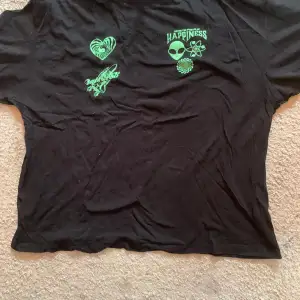 Svart T-shirt med grönt rymdtryck. 100% bomull