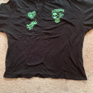 Svart T-shirt med rymd-tryck - Svart T-shirt med grönt rymdtryck. 100% bomull