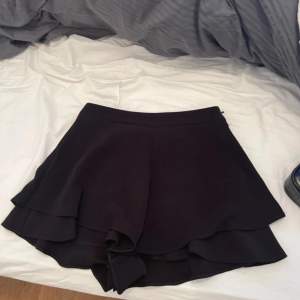 En svart shorts kjol i storlek M från zara
