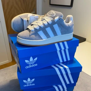ADIDAS CAMPUS 00s ”GREY WHITE” - Säljer ett till par helt nya campus i den grå färgen perfekta till våren och sommaren! Köpta på adidas. Skriv för frågor och fler bilder! Kvitto och box finns. 