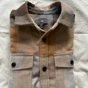 Rutig Skjorta - En fin rutig skjorta/overshirt från HM, lite tjockare material som värmer och skyddar från elementen bra. Perfekt inför våren och till hösten. Använd men fortfarande väldigt bra skick, 8/10. Skriv vid frågor eller fler bilder!!