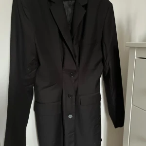 Svart kavaj klänning  - En svart kavaj klänning, är även axelvaddar i som man inte kan ta ut, 