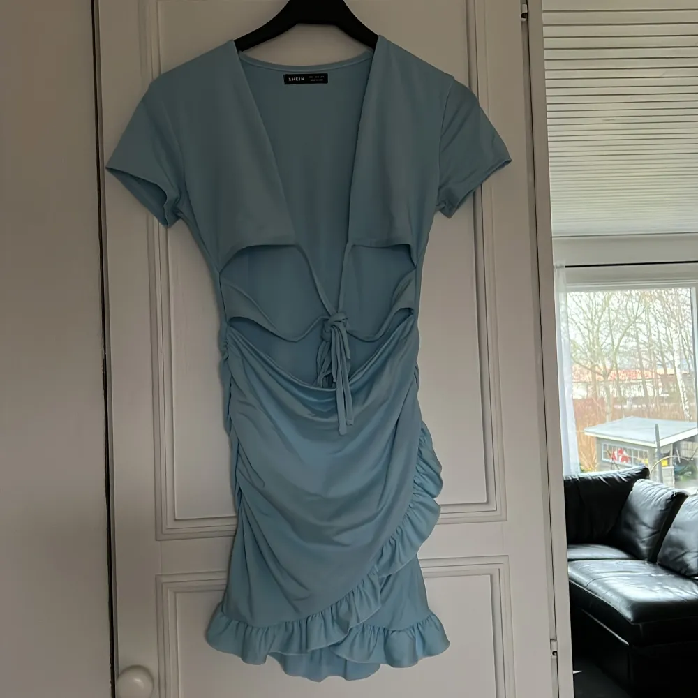 Ljusblå klänning strl S med snörning fram till. Polyester och spandex. Använd Max 1 gång. Katt och hund finns i hemmet. . Mekot.