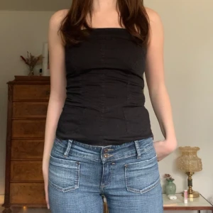 Korsettopp - Svart tubtopp i lite korsettmodell och jeansmaterial, har knappar i ryggen, fickor framtill och dragkedja i sidan! Från okänt märke ✨