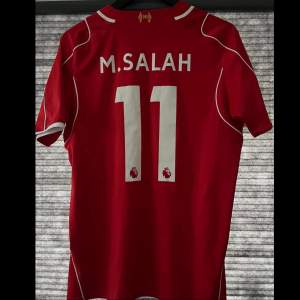 Tjena! Säljer en äkta Liverpool tröja från 2014-2015 men Mohammed Salah på ryggen den är i storlek M och har något vit drag på fram sidan ner till höger men annars så är den i bra skick. Lappen med produkt koden är av klippt. Fråga vid funderingar😁
