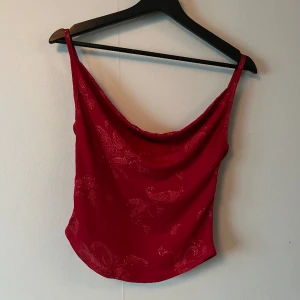 Röd fest topp - Röd fest topp med glittrigt mönster❤️💃 Säljer då den inte kommer till användning. Den är köpt secondhand och det står ingen stolek men skulle uppskatta den som en S❤️‍🔥