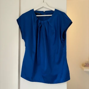 Blå blus - Blå blus i sidenliknande material. Köpt second hand, aldrig använd av mig. Storlek M
