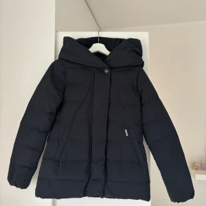 Mörkblå dunjacka  - Marinblå pufferjacka. Köpt på eBay. Står storlek 14, skulle säga att den passar S. Köpt för 1500kr