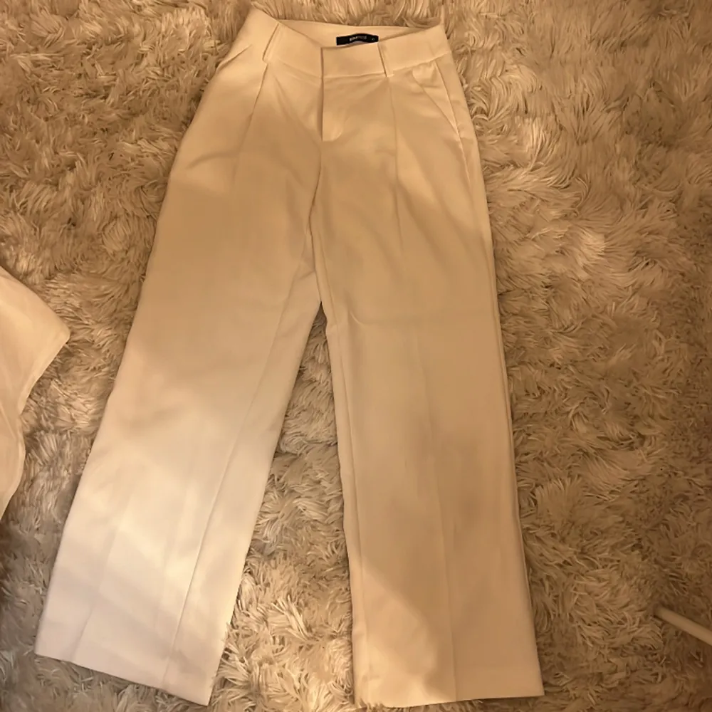 Ett par vita kostymbyxor från Gina Tricot. De är i storlek XS men skulle kunna funka som storlek S också pga den vida passformen. Väldigt bra skick, har bara används en gång.. Jeans & Byxor.