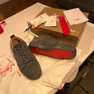 Christian Louboutin - Ett par gråa loubs som är i ny skick allt og följer med (skohorn, snören, extra nitar) Storlek 43 men passar 42, Inte skador alls på skorna. 