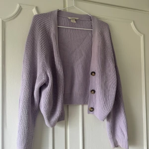 Stickad kofta  - Ljuslila stickad kofta från Monki använd fåtal gånger, kortare modell 