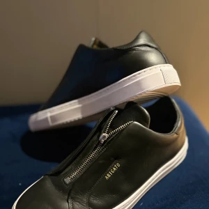 Axel arigato skor  - De är i ett väl skick. Jag säljer dessa Axel Arigato skor på grund av en lite för stor storlek. Dragkedjan finns inte men man kan dra dragkedjan ändå på ett lite klurigare sätt