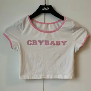 En vit babytee med rosa detaljer och text där det står ”Cry baby” från SHEIN i strl S!💓